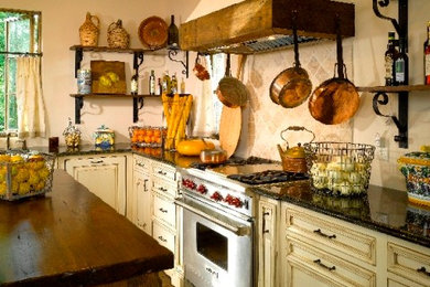 Example of a mid-sized mountain style u-shaped medium tone wood floor eat-in kitchen design in Charlotte with a farmhouse sink, raised-panel cabinets, granite countertops, stainless steel appliances and an island