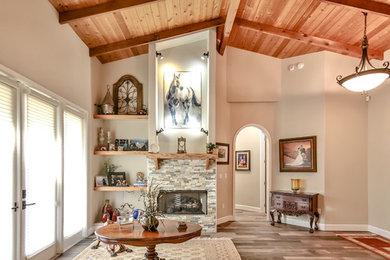 Example of a mid-sized mountain style open concept porcelain tile and brown floor living room design in Miami with beige walls, a standard fireplace, a stone fireplace and no tv