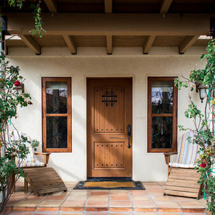 Новый формат декора квартиры: входная дверь в средиземноморском стиле с полом из терракотовой плитки, одностворчатой входной дверью и входной дверью из дерева среднего тона