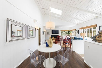 Photo of a small beach style open plan dining in Los Angeles with white walls, dark hardwood floors, no fireplace and brown floor.