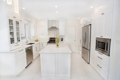 Transitional u-shaped ceramic tile eat-in kitchen photo in Other with an undermount sink, recessed-panel cabinets, white cabinets, quartz countertops, gray backsplash, matchstick tile backsplash, stainless steel appliances and an island