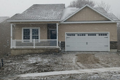 Transitional beige one-story vinyl and clapboard exterior home photo in Other with a shingle roof and a brown roof