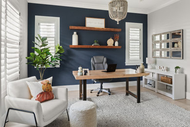 Example of a transitional freestanding desk light wood floor and beige floor home office design in Orlando with blue walls