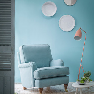 Immagine di un soggiorno minimalista di medie dimensioni e chiuso con libreria, pareti blu, pavimento in legno verniciato, nessun camino e nessuna TV