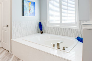 Mid-sized trendy master gray tile and ceramic tile laminate floor and beige floor bathroom photo in Toronto with flat-panel cabinets, medium tone wood cabinets, a one-piece toilet, gray walls, a vessel sink, quartz countertops and a hinged shower door