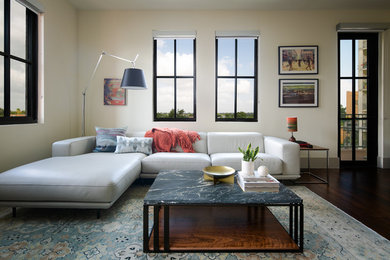 Inspiration for a mid-sized contemporary enclosed medium tone wood floor living room remodel in Austin with beige walls and a tv stand