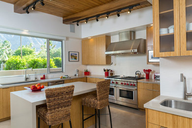 Inspiration for a contemporary l-shaped ceramic tile and beige floor kitchen remodel in Los Angeles with a double-bowl sink, flat-panel cabinets, light wood cabinets, quartz countertops, white backsplash, ceramic backsplash, stainless steel appliances and an island