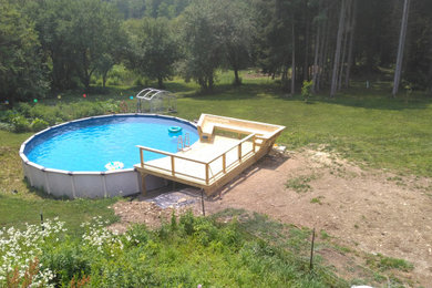 Example of a mid-sized arts and crafts backyard ground level cable railing deck design in New York