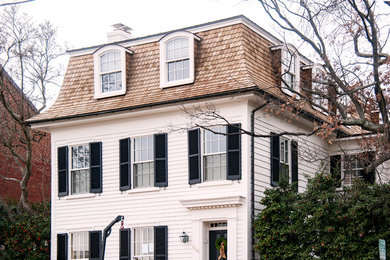 Large elegant white three-story wood house exterior photo in DC Metro with a gambrel roof and a shingle roof