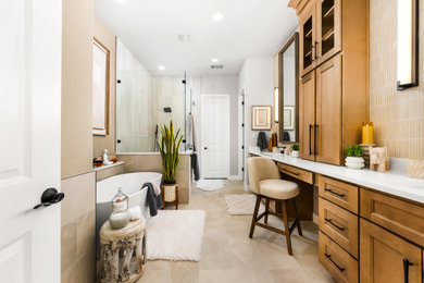 Example of a large transitional beige tile and porcelain tile porcelain tile and double-sink freestanding bathtub design in Austin with shaker cabinets, brown cabinets, a two-piece toilet, beige walls, an undermount sink, quartz countertops, white countertops, a niche and a built-in vanity