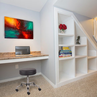 Medium sized modern home office and library in Calgary with blue walls, carpet and a built-in desk.