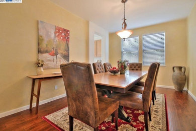 Example of a mid-sized classic dark wood floor and brown floor enclosed dining room design in Sacramento with beige walls and no fireplace