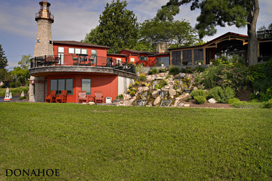 Cette image montre une façade de maison rouge traditionnelle de taille moyenne avec un revêtement mixte.