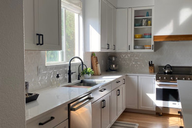 Kitchen - large contemporary u-shaped medium tone wood floor and exposed beam kitchen idea in Denver with an undermount sink, shaker cabinets, white cabinets, quartz countertops, white backsplash, porcelain backsplash, stainless steel appliances, an island and white countertops