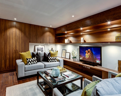Modern enclosed family and games room in London with white walls and medium hardwood flooring.