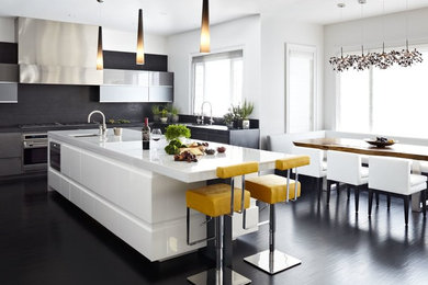 Photo of a contemporary l-shaped eat-in kitchen in Los Angeles with an undermount sink, flat-panel cabinets, white cabinets and black splashback.