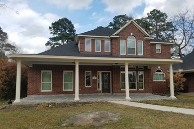 Example of a mid-sized ornate front yard stone patio design in Houston with a roof extension