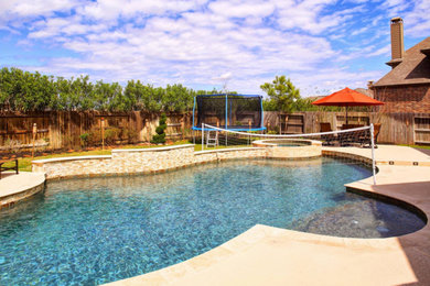 Inspiration for a large contemporary backyard custom-shaped natural pool in Houston with a water feature and natural stone pavers.
