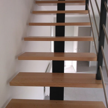 Escalier 1/4 tournant à limon central bois teinté gris anthracite et marches en