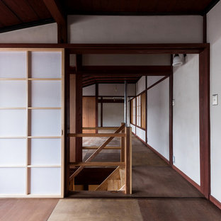 Foto di una camera da letto etnica con pareti grigie, pavimento in compensato e pavimento marrone