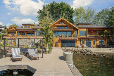 Example of a large mountain style brown three-story mixed siding and clapboard exterior home design in Seattle with a mixed material roof and a gray roof