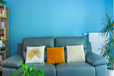 Idée de décoration pour un salon de taille moyenne et ouvert avec un bar de salon, un mur bleu, sol en stratifié, un téléviseur indépendant et un sol marron.