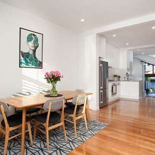 Photo of a contemporary open plan dining in Sydney with white walls, medium hardwood floors, no fireplace and brown floor.