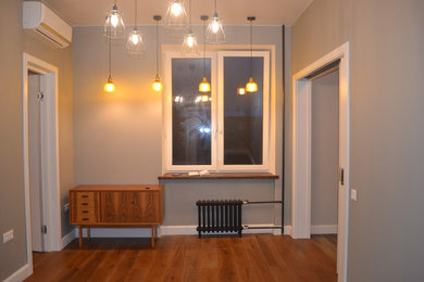 На фото: гостиная комната среднего размера в скандинавском стиле с серыми стенами, темным паркетным полом, отдельно стоящим телевизором и коричневым полом