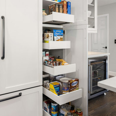 Elegant kitchen photo in Portland with shaker cabinets, quartzite countertops, white backsplash, stainless steel appliances, an island and white countertops