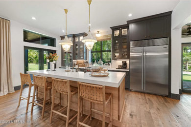 Example of an eat-in kitchen design in Jacksonville with flat-panel cabinets, black cabinets and an island