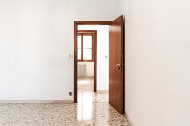 Foto di una camera da letto minimalista di medie dimensioni con pareti bianche, pavimento in marmo e pavimento multicolore