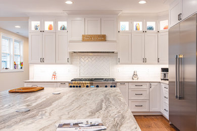Eat-in kitchen - mid-sized u-shaped laminate floor and brown floor eat-in kitchen idea in DC Metro with an integrated sink, shaker cabinets, white cabinets, granite countertops, white backsplash, stone slab backsplash, stainless steel appliances, an island and gray countertops