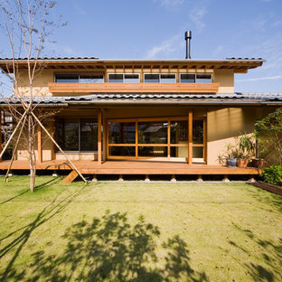 他の地域のアジアンスタイルのおしゃれな二階建ての家 (茶色い外壁、切妻屋根、戸建、瓦屋根) の写真