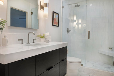 Exempel på ett litet modernt vit vitt badrum med dusch, med släta luckor, svarta skåp, en dusch i en alkov, en toalettstol med hel cisternkåpa, vit kakel, keramikplattor, vita väggar, klinkergolv i keramik, ett undermonterad handfat, bänkskiva i kvarts, vitt golv och dusch med gångjärnsdörr