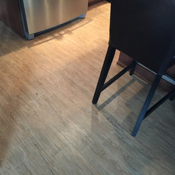 Harlequin glass backsplash with porcelain wood look floor.