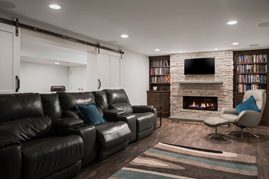 Large transitional fully buried basement in Columbus with white walls, vinyl floors, a standard fireplace, a stone fireplace surround and brown floor.