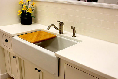 Kitchen pantry - mid-sized traditional l-shaped medium tone wood floor kitchen pantry idea in Providence with an undermount sink, raised-panel cabinets, white cabinets, granite countertops, beige backsplash, stone tile backsplash, white appliances and an island