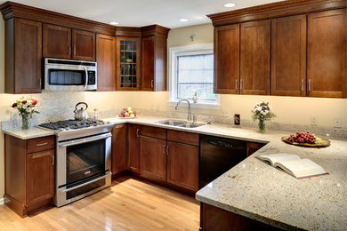 Inspiration for a small timeless u-shaped light wood floor enclosed kitchen remodel in Philadelphia with a double-bowl sink, shaker cabinets, dark wood cabinets, granite countertops, beige backsplash, stainless steel appliances and an island
