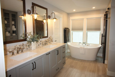 Large beach style master gray tile and porcelain tile porcelain tile and gray floor bathroom photo in Seattle with shaker cabinets, gray cabinets, a two-piece toilet, gray walls, an undermount sink, quartz countertops, a hinged shower door and white countertops