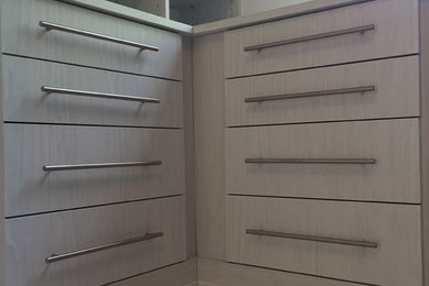 Walk-in closet - large transitional light wood floor and beige floor walk-in closet idea in Detroit with white cabinets