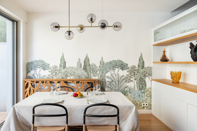 Diseño de comedor actual pequeño abierto con paredes blancas, suelo de madera clara y papel pintado