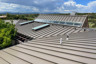 Diseño de fachada marrón minimalista grande con tejado plano y tejado de metal