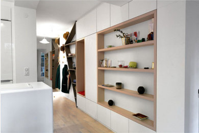 Cette photo montre un hall d'entrée tendance de taille moyenne avec un mur blanc et un sol beige.
