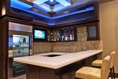 This is an example of a large contemporary home bar in Las Vegas with travertine floors.