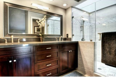 Design ideas for a mid-sized transitional master bathroom in Orange County with shaker cabinets, dark wood cabinets, an alcove shower, a two-piece toilet, gray tile, porcelain tile, porcelain floors, an undermount sink and engineered quartz benchtops.
