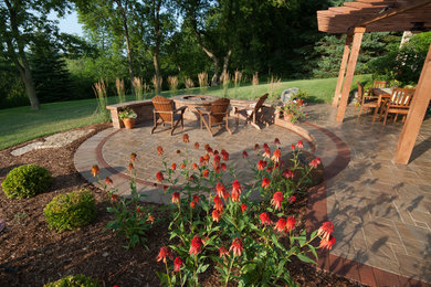 Inspiration for a mid-sized traditional backyard full sun garden in Milwaukee with concrete pavers.