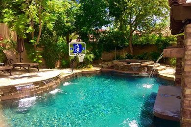 Pool fountain - large mediterranean backyard stamped concrete and custom-shaped natural pool fountain idea in Phoenix