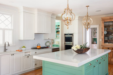 Kitchen - eclectic light wood floor kitchen idea in Atlanta with an undermount sink, raised-panel cabinets, white cabinets, white backsplash, subway tile backsplash, stainless steel appliances and an island