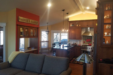 Photo of a mid-sized traditional u-shaped kitchen in Chicago with medium wood cabinets, medium hardwood floors, with island and brown floor.