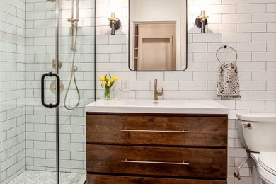 Example of an urban master white tile and porcelain tile porcelain tile, black floor and single-sink bathroom design in New York with flat-panel cabinets, dark wood cabinets, an integrated sink, solid surface countertops, white countertops, a niche and a freestanding vanity